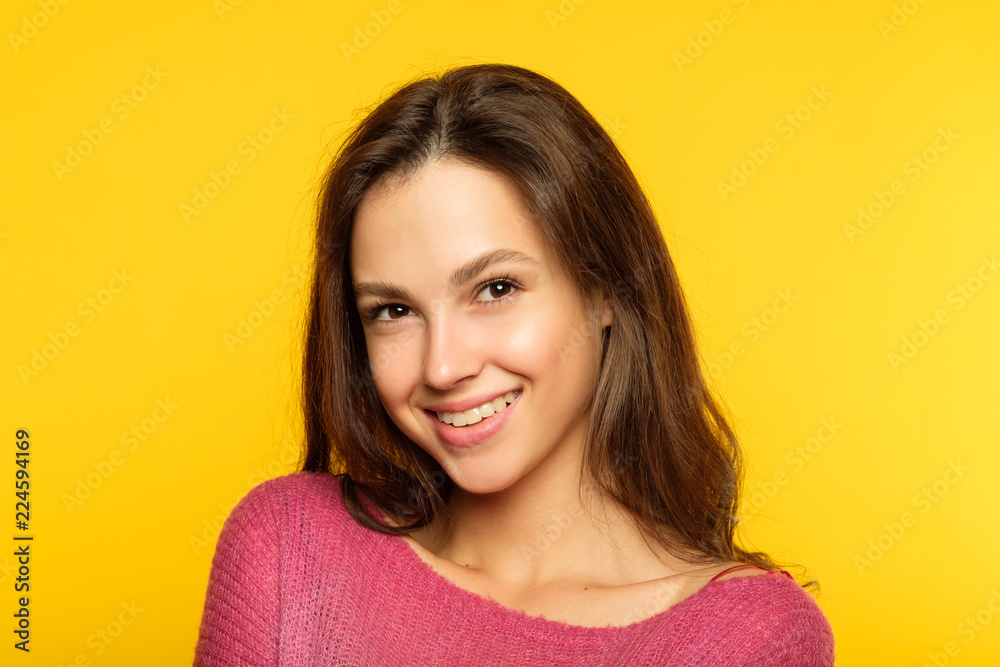 emotion face. smiling woman pleased with herself. self-satisfied young beautiful brown haired girl. portrait on yellow background. emotion face. smiling woman pleased with herself. self-satisfied young beautiful brown haired girl. portrait on yellow background.