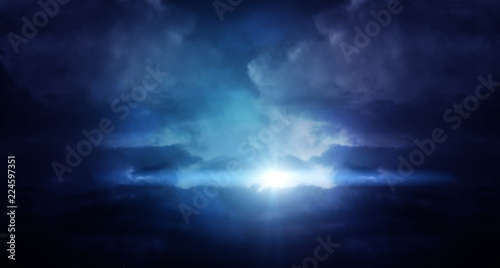 Abstract dark background of a night sky with clouds, a glow of the moon. The background of the storm sky