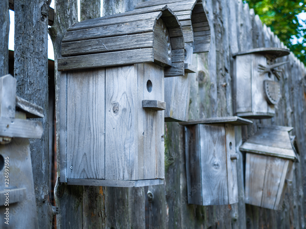 wooden birdhouses on a log wall