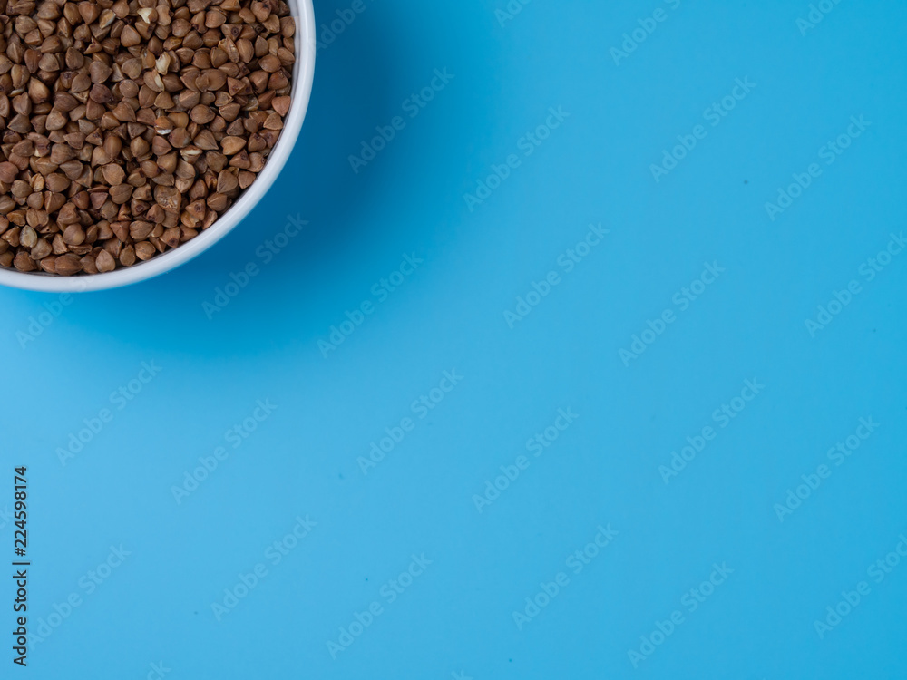 buckwheat in white cup on a blue background buckwheat in white cup on a blue background