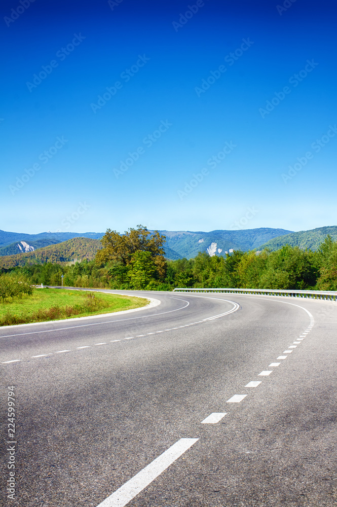 The road in mountainous terrain, sharp turns. Summer landscape. Serpentine road. Asphalt coating. Natural nature.