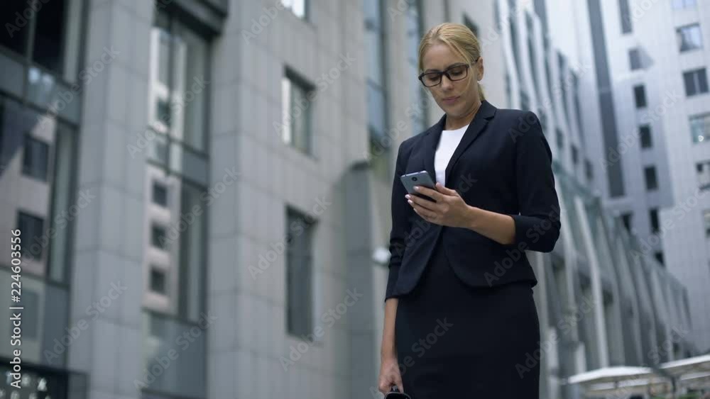 Businesswoman reads bad news on cell phone, failed startup and bankruptcy Businesswoman reads bad news on cell phone, failed startup and bankruptcy