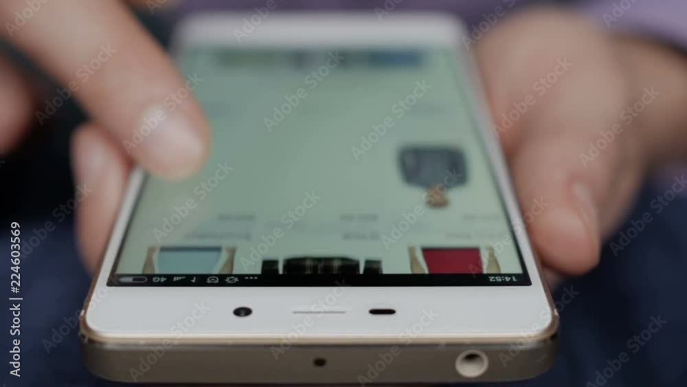 A man looks at the goods in the online clothing store. People using Smartphone, online shopping. The screen is blurred.  Close-up. 4K UHD.