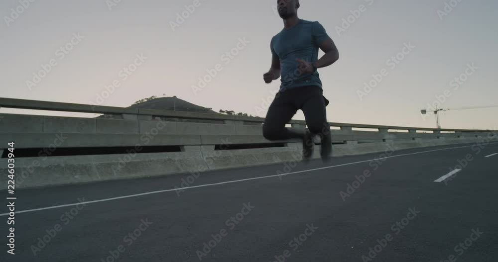 young african american runner man stretching preparing for running workout performing warm up exercise in urban city at sunrise enjoying healthy fitness lifestyle