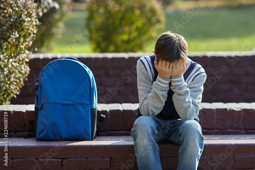 Schoolboy crying in the yard of the school