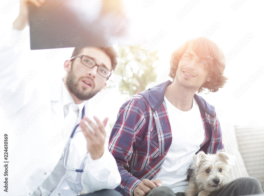 veterinarian showing an x-ray to the owner of the dog. veterinarian showing an x-ray to the owner of the dog.