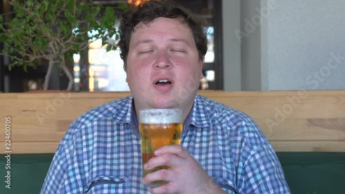 Big man is sniffing beer and like it