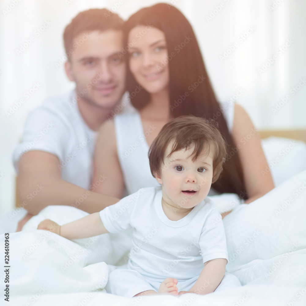 Portrait of a joyful family sitting on the bed at home Portrait of a joyful family sitting on the bed at home