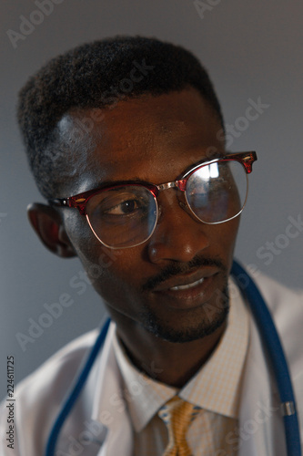 Handsome guy doctor in white lab coat with stethoscope on white background