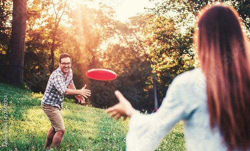 Tableau sur toile Happy couple playing frisbee in the park
