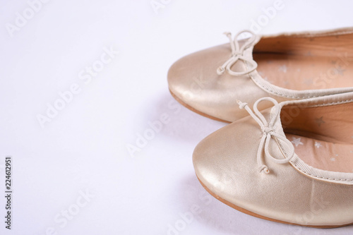 Kids shoes of gold colour.Moccasins for little princess