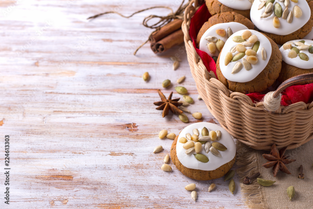 Fragrant Christmas gingerbread with glaze, nuts and seeds in a basket on a wooden background, free space, closeup, horizontal