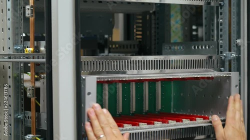 Male hand installing modules in 19-inch server rack box photo