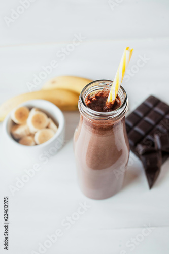 Banana and chocolate smoothie in the glass jar milkshakes, natural and organic drink