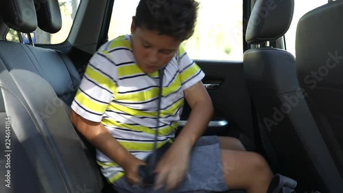 Child Fastening A Seat Belt In The Car photo