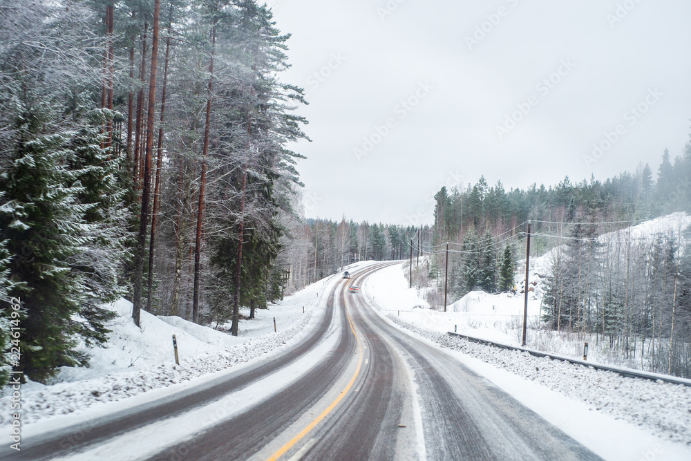 Car with lights on a snow covered road.