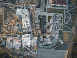 Construction site with building cranes and other equipment, industrial built or estate development modern buildings, aerial view