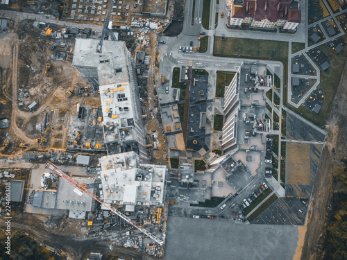 Construction site with building cranes and other equipment, industrial built or estate development modern buildings, aerial view