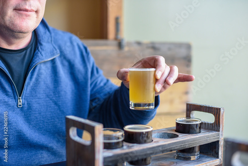 Man sampling beer from a flight at local microbrewery