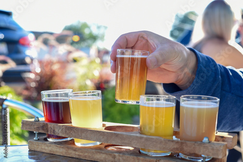 Fotografia Man sampling beer at an outdoor beer garden, hands only