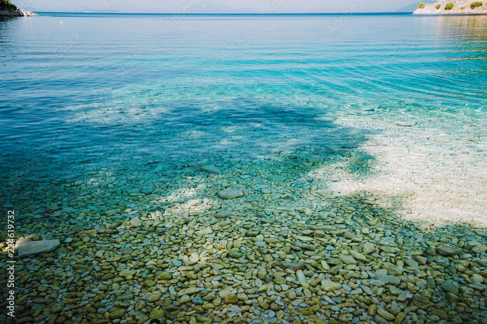Stones seen through the crystal clear waters of mediterranean sea. Calm turquoise water