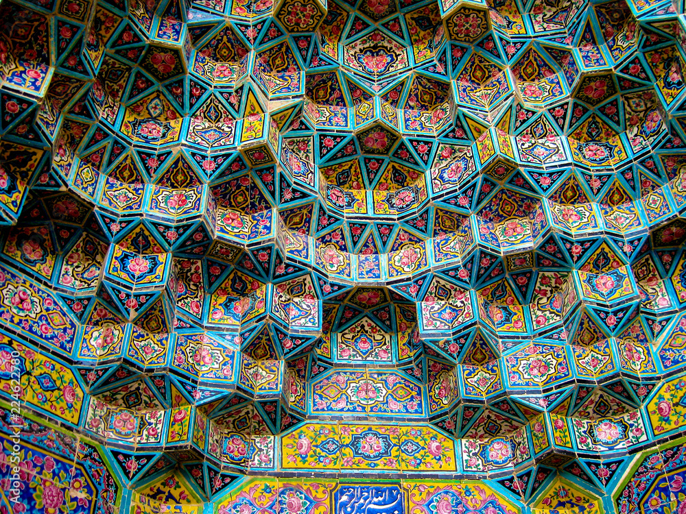 Detail of colorful, patterned stalactite moulding decorations above a door in the spectacular Nasir al-Mulk Mosque (also known as the Pink Mosque) in Shiraz, in southern Iran