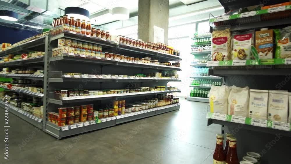 Grocery store interiors, with decked up shelves brightly lit in Warsaw Poland (moving gimbal shot)