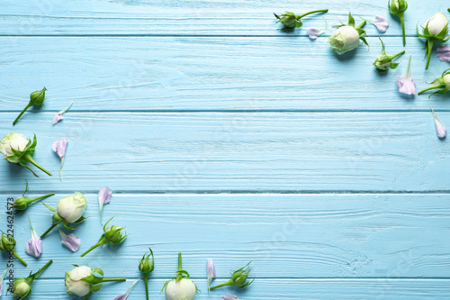 Flat lay composition with beautiful blooming flowers on wooden background