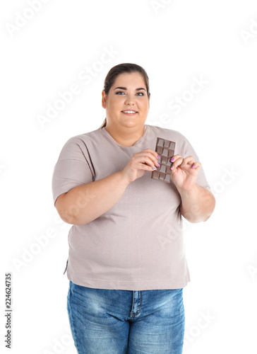 Overweight woman with chocolate bar on white background
