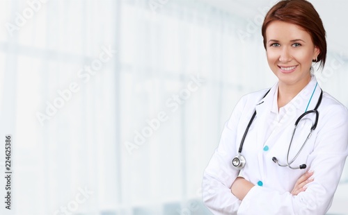 Attractive young female doctor on background