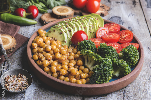 Healthy vegan salad with avocado , chickpeas , broccoli , tomato