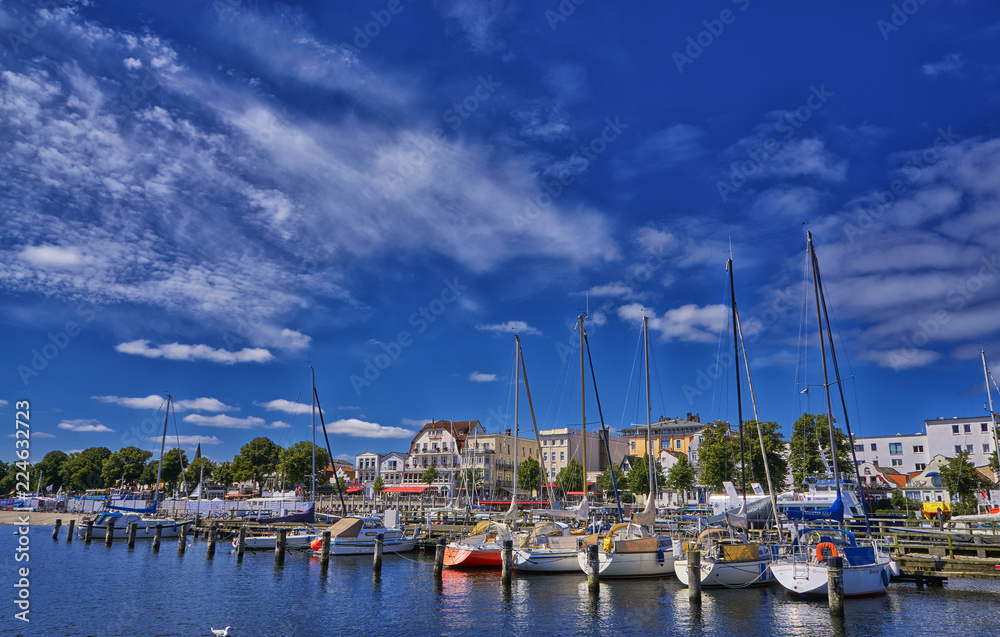 Colorful sailing boats resting in the peaceful Alter Strom Canal in Warnemunde, Rostock, Mecklenburg-Western Pomerania, Germany.