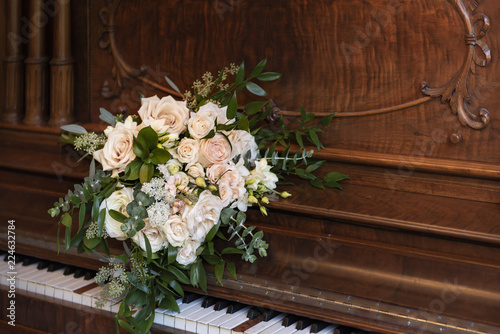 Wedding bridal bouqet on the vintage old wooden piano © Kristina