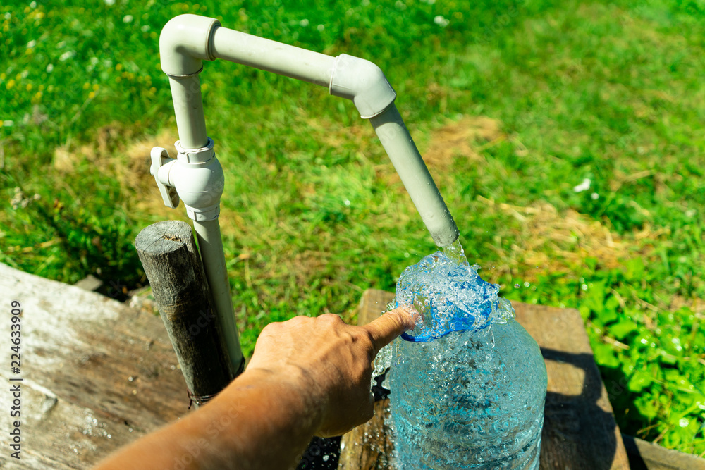 Naklejka premium A person collects water in a container. Water supply problem.