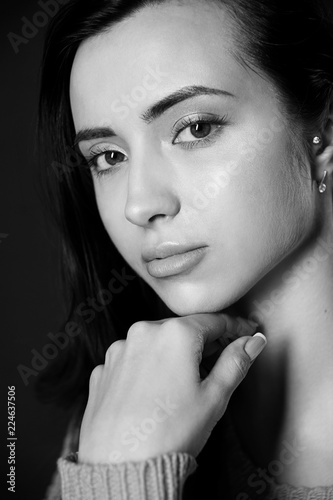 Black and white photo of beautiful brunette girl posing in studio.