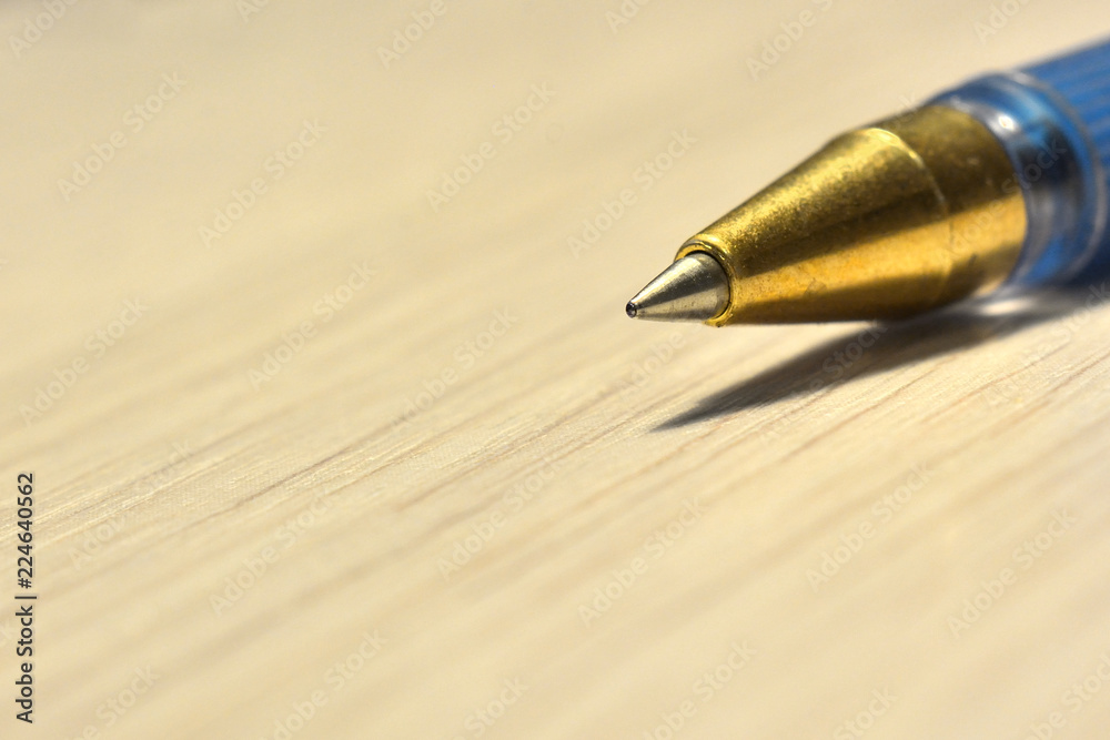 tip of ballpoint pen on wooden table close-up tip of ballpoint pen on wooden table close-up