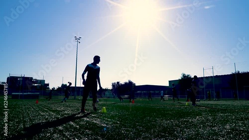Silhouette Of Teenagers Training Football in Back-light at noon. photo