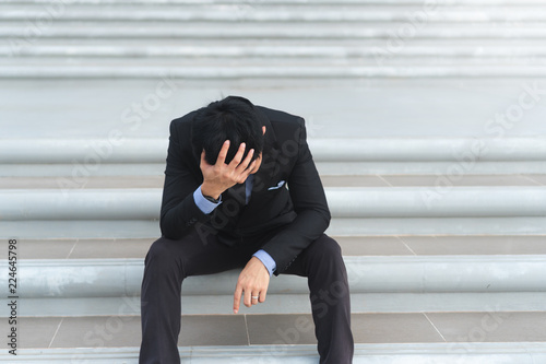 Fotografie Young asian businessman sitting and holding head with hand are stressed with work and life issues