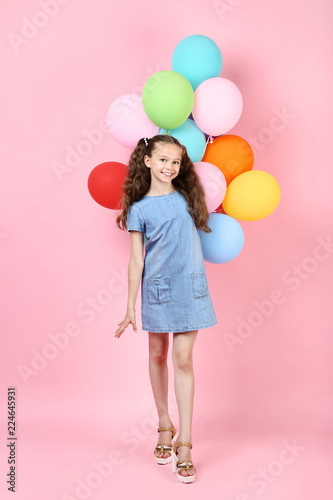 Young girl with colored balloons on pink background © 5second