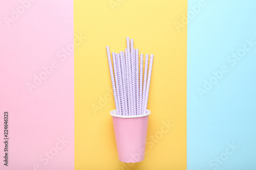Pink paper cup with straws on colorful background