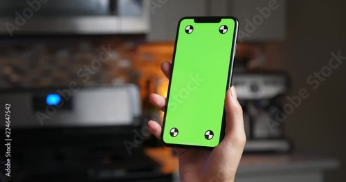 Woman holding green screen smartphone
