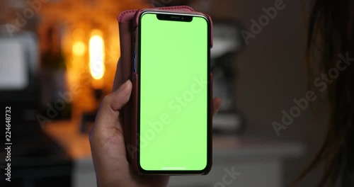 Woman holding green screen smartphone