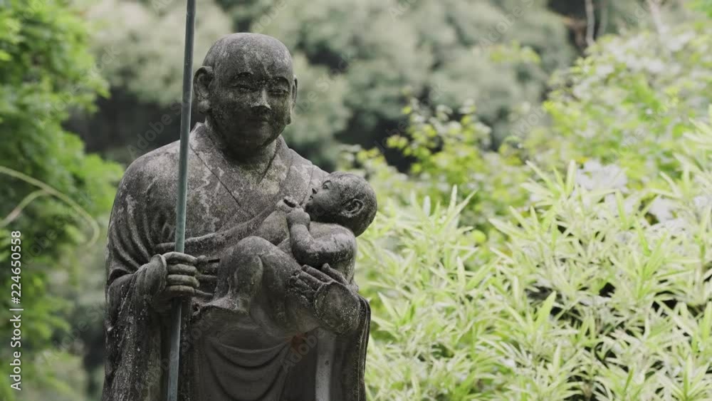 Statue of a Man Holding a Child, Bamboo Background Statue of a Man Holding a Child, Bamboo Background