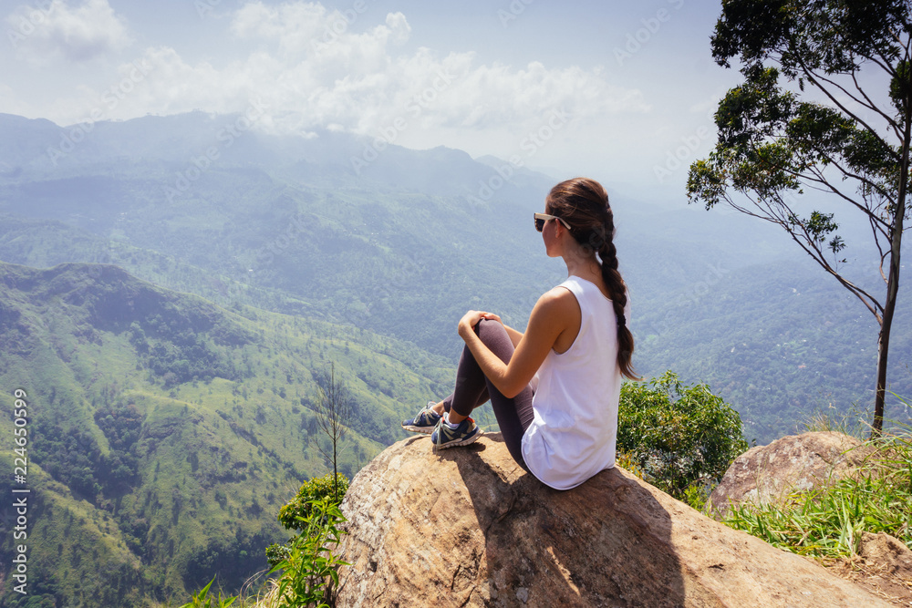 Tracking tourist adventure. Woman sitting on the top of Ella rock, Sri Lanka. Tracking tourist adventure. Woman sitting on the top of Ella rock, Sri Lanka.