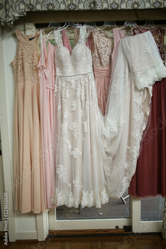 Wedding Photography Mismatched Pink Bridesmaid Dresses Hanging in front of French Doors © holly