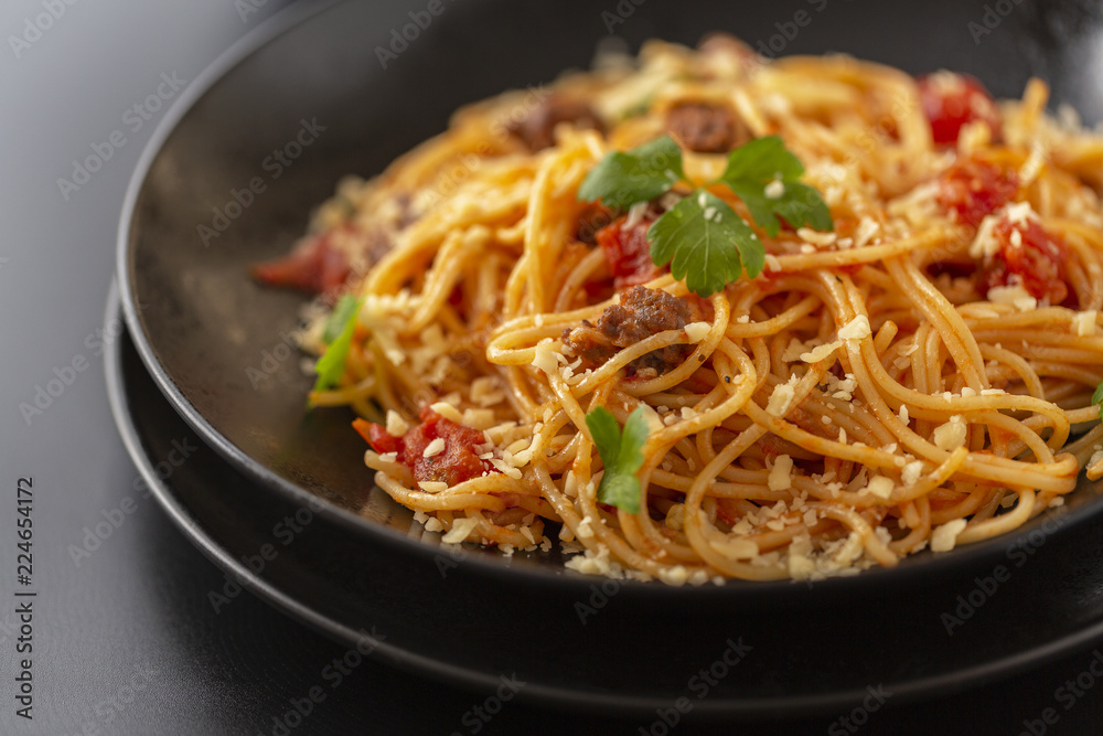 Delicious spaghetti with Bolognese sauce served on a black plate