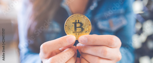 Woman hand holding a currency bitcoin.