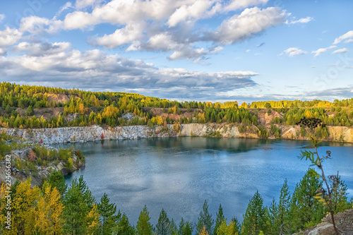 Autumn landscape with colourful forest around the lake. Beautiful autumn trees around the forest lake. The concept of hiking.