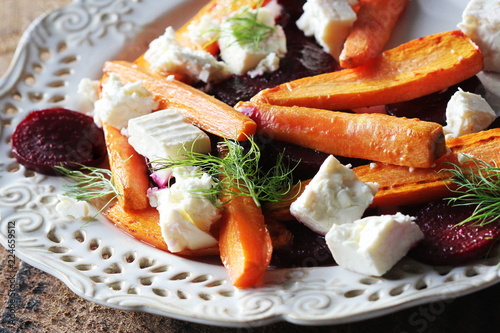 Healthy grilled beet, carrots salad with cheese feta, fennel on the rustic wooden table