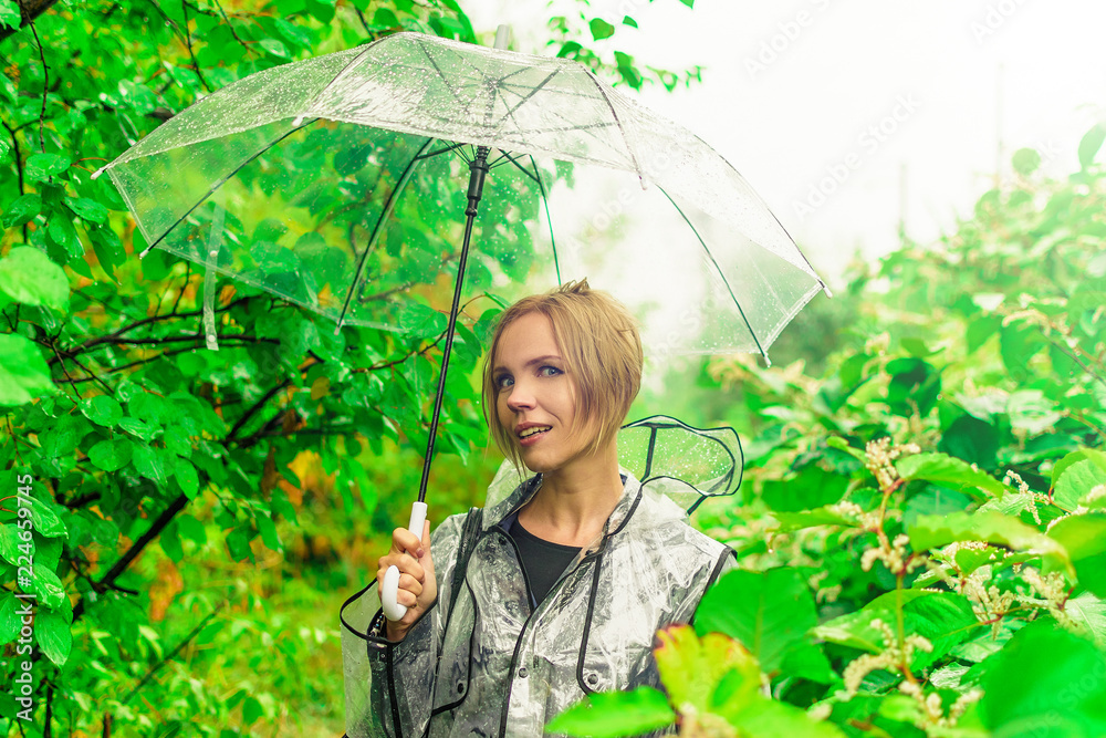 A middle-aged woman under a transparent umbrella in autumn in the foliage. A middle-aged woman under a transparent umbrella in autumn in the foliage.